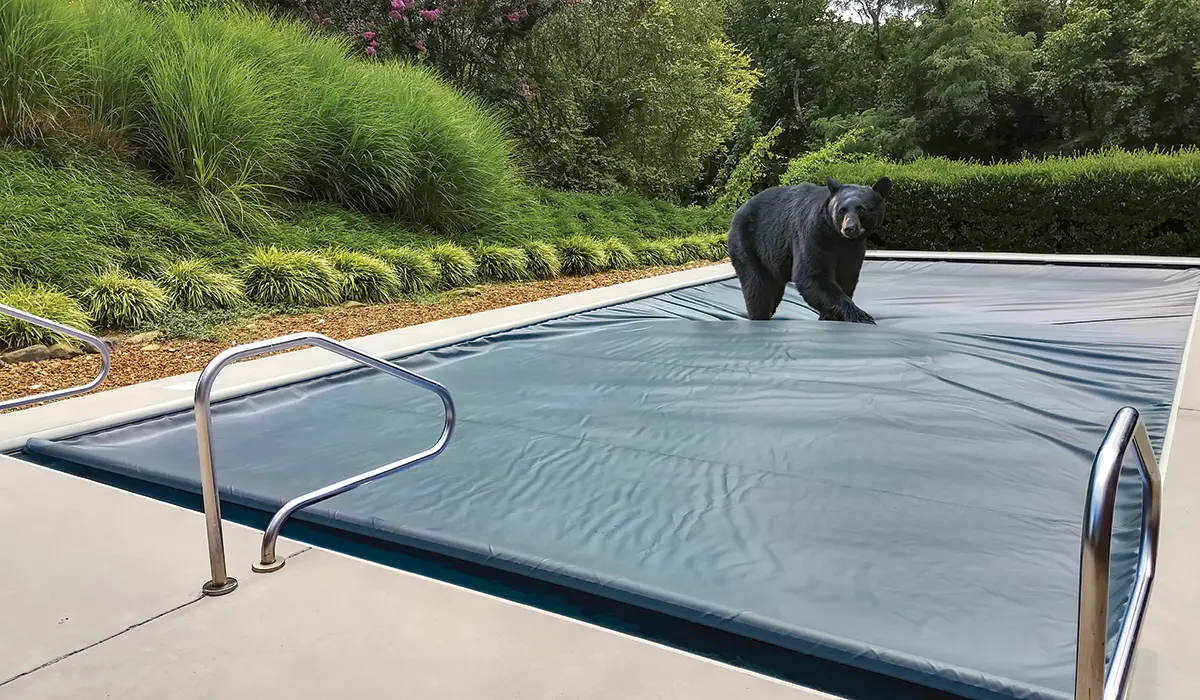 Durable automatic pool cover system protecting an in-ground pool from sun, storms, and seasonal debris.